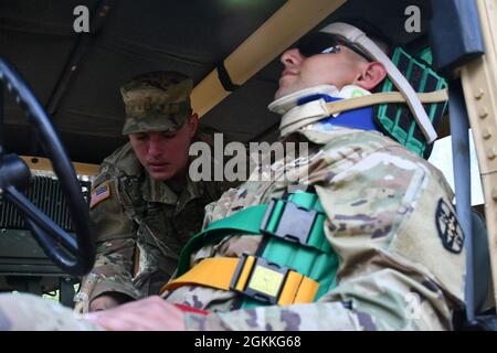 2. LT. Seth Skaggs, ein Aeromedizinischer Evakuierungsbeauftragter der Nationalgarde von West Virginia, kümmert sich um Sgt. Christopher Colley, ein Rollenspieler des Army Reserve Medical Command, während einer Expert Field Medical Badge Testveranstaltung, die vom 16. Bis 22. Mai 2021 in Fort McCoy, Wisconsin, stattfand. Diese EFMB-Veranstaltung ist die erste Veranstaltung der Army Reserve und bietet Soldaten im medizinischen Bereich die Möglichkeit, den Sonderpreis für besondere Fähigkeiten zu erhalten, indem sie außergewöhnliche Kompetenz und herausragende Leistungen bei Soldaten- und medizinischen Aufgaben unter Beweis stellen. Weniger als zwanzig Prozent der Kandidaten bestehen den anspruchsvollen Test. Stockfoto