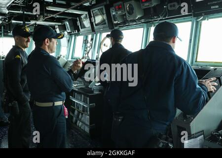 NORDSEE (17. Mai 2021) Seeleute, die an Bord des Arleigh Burke-Klasse Lenkraketen-Zerstörers USS Ross (DDG 71) stationiert sind, beobachten, wie das Schiff an einer Fotoübung im Rahmen der Übung At-Sea Demo/Formidable Shield SD/FS in der Nordsee teilnimmt, 17. Mai 2021. ASD/FS, die von der NATO für Marinestreik- und Unterstützungsstreitkräfte im Auftrag der Sechsten US-Flotte durchgeführt wird, ist eine integrierte Luft- und Raketenabwehr (IAMD)-Übung, die die Interoperabilität der Alliierten mithilfe von NATO-Kommando- und Kontrollmeldestrukturen verbessert. Stockfoto