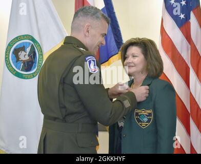 FORT CARSON, Colo. – der Generalmajor Matthew W. McFarlane, Kommandeur der 4. Infanterie-Division und Fort Carson, pinnt die Fort Carson Good Neighbor Pin auf Deanne Funkhousers Jacke bei der 43. Jährlichen Fort Carson Good Neighbor Induction Ceremony am 17. Mai 2021 im Elkhorn Conference Center. Stockfoto