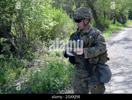 FORT DRUM, N.Y. – CPL der US-Armee. Dakoatah Miller, ein Infanterist des 2. Bataillons der New Yorker Nationalgarde, des 108. Infanterie-Regiments, führt den Landnavigationsteil der 10. Mountain Division Expert Infantryman Badge (EIB)-Beurteilung in Fort Drum, N.Y., 18. Mai 2021 durch. Bei den Tests der EIB handelt es sich um eine fünftägige Bewertung, die sich auf die Landschifffahrt, die Waffenqualifikation, einen 12-Meilen-marsch und mehrere Einzelaufgaben zur Prüfung der Infanteriefähigkeiten konzentriert. Stockfoto