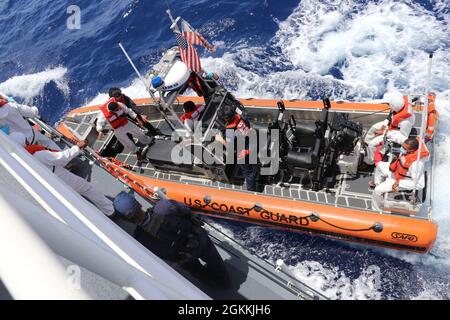 Die Besatzung des Küstenwache-Cutter Donald Horsley führt 66 Migranten in ein Patrouillenboot der Dominikanischen Republik vor Punta Cana, Dominikanische Republik, zurück, 18. Mai 2021, nachdem zwei illegale Reisen in den Gewässern der Mona-Passage vor Puerto Rico verboten wurden. Die Verbote sind das Ergebnis der anhaltenden Bemühungen der Partnerorganisationen der Caribbean Border InterAgency Group (CBIG), die Grenzen von Puerto Rico gegen illegalen Migrant/innen- und Drogenschmuggel zu sichern. Stockfoto