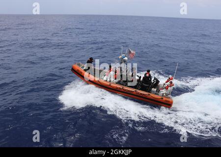 Die Besatzung des Küstenwache-Cutter Donald Horsley führt 66 Migranten in ein Patrouillenboot der Dominikanischen Republik vor Punta Cana, Dominikanische Republik, zurück, 18. Mai 2021, nachdem zwei illegale Reisen in den Gewässern der Mona-Passage vor Puerto Rico verboten wurden. Die Verbote sind das Ergebnis der anhaltenden Bemühungen der Partnerorganisationen der Caribbean Border InterAgency Group (CBIG), die Grenzen von Puerto Rico gegen illegalen Migrant/innen- und Drogenschmuggel zu sichern. Stockfoto