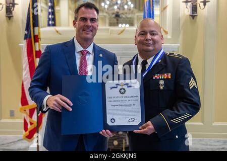 Kevin J. Stitt, Gouverneur von Oklahoma, posiert mit der Oklahoma Army National Guard Sgt. Pedro Gonzales III. Nachdem er ihm die Oklahoma Medal of Valor während einer Zeremonie im Oklahoma State Capitol in Oklahoma City, am 18. Mai 2021 überreicht hatte. Die Oklahoma Medal of Valor ist die höchste Auszeichnung des Staates Oklahoma, die einem Mitglied einer öffentlichen Sicherheitsbehörde oder einem Mitglied der Öffentlichkeit verliehen wird. Stockfoto