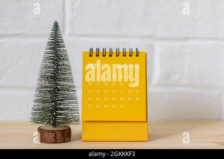 Der Kalender ist der 2021. Dezember.Ein Desktop-Kalender und ein kleiner Weihnachtsbaum auf dem Tisch Stockfoto