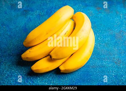 Zweig der Bananen auf dem rustikalen Hintergrund. Selektiver Fokus. Geringe Schärfentiefe. Stockfoto