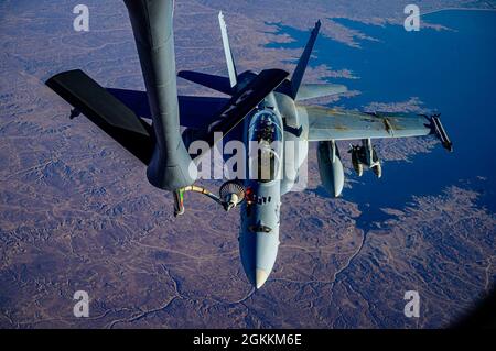 Ein US Marine Corps F/A-18D Hornet-Flugzeug vom Marine All Weather Attack Squadron 224, Marine Aircraft Group 31, nähert sich dem Auftanken eines US Air Force KC-135 Stratotanker-Flugzeugs während einer Mission, die einen dynamischen Krafteinsatz über den Verantwortungsbereich des U.S. Central Command unterstützt, 18. Mai 2021. Dynamische Operationen und der Einsatz von Gewalt im Theater unterstreichen die Fähigkeit des US-Militärs, Truppen überall auf der Welt einzusetzen und einzusetzen. Stockfoto