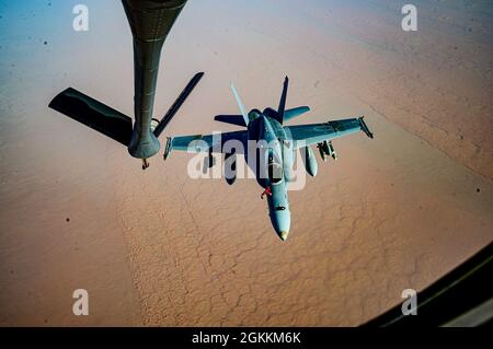 Ein US Marine Corps F/A-18D Hornet-Flugzeug vom Marine All Weather Attack Squadron 224, Marine Aircraft Group 31, nähert sich dem Auftanken eines US Air Force KC-135 Stratotanker-Flugzeugs während einer Mission, die einen dynamischen Krafteinsatz über den Verantwortungsbereich des U.S. Central Command unterstützt, 18. Mai 2021. Dynamische Operationen und der Einsatz von Gewalt im Theater unterstreichen die Fähigkeit des US-Militärs, Truppen überall auf der Welt einzusetzen und einzusetzen. Stockfoto