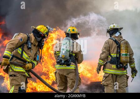 Feuerwehrmänner, die dem 180. Kampfflügel der Ohio National Guard zugewiesen wurden, sowie mehrere örtliche Feuerwehren, löschten am Eugene F. Kranz Toledo Express Airport in Swanton, Ohio, am 18. Mai 2021 einen kontrollierten Brand aus. Die Übung gab lokalen militärischen und zivilen Ersthelfern die Möglichkeit, gemeinsam an hochwertigen praktischen Erfahrungen in einem gemeinsamen Umfeld zu arbeiten und sicherzustellen, dass sie für den Fall eines realen Flugzeugversages bereit sind. Stockfoto