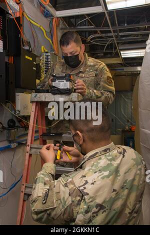 RIVERSIDE, Kalifornien, (18. Mai 2021) US Air Force Tech. Sgt. Javiel Ladines und U.S. Army Sgt. 1. Klasse Adam Lozano, Defense Media Activity Riverside (DMA-R), Television-Audio Support Activity (T-ASA) Bereiten Sie Glasfaserkabel für die Installation eines DMA-R-Netzwerk-Upgrades vor. T-ASA bietet dem Verteidigungsministerium eine breite Palette an Unterstützung für Visual Information Engineering. Stockfoto