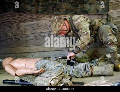 FORT DRUM, N.Y. – CPL der US-Armee. Dakoatah Miller, ein Infanterist des 2. Bataillons der New Yorker Nationalgarde, des 108. Infanterie-Regiments, wendet während der 10. Mountain Division Expert Infantryman Badge Assessment in Fort Drum, N.Y., 19. Mai 2021 eine Gefechtsabwehr auf einen simulierten Unfall an. Zehn Infanteriesoldaten und ein Sanitäter aus dem Kampfteam der 27. Infanteriebrigade nahmen an der fünftägigen Prüfung Teil, um die begehrten Abzeichen „Expert Infantryman“ und „Expert Field Medic“ zu erhalten. Stockfoto