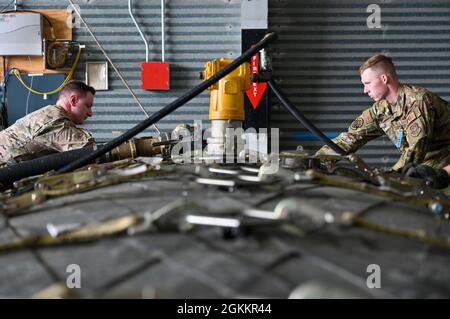 US Air Force Staff Sgt. Garrett Huntoon, 374. Logistic Readiness Squadron Fuels Service Center Controller, links, und Airman 1st Class Griffin Nelson, 436. Logistics Readiness Squadron Fuels Operator, strap down an Aerial Bulk Fuel Delivery System at Alpena Combat Readiness Training Center, Michigan, 19. Mai 2021. Die ABFDS, eine tragbare Kraftstoffblase mit 3,000 Gallonen, kann auf eine C-130J Super Hercules, C-5 Galaxy oder C-17 Globemaster III geladen und überall auf der Welt transportiert werden. Stockfoto