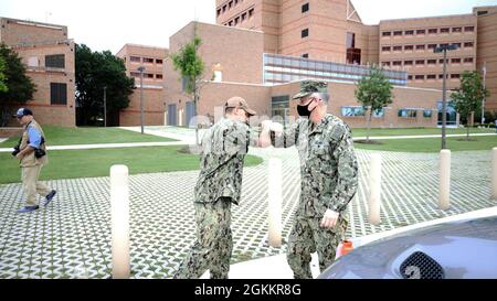 Hinterer Adm. Tim Weber, Kommandant der Naval Medical Forces Pacific, wird von LT. Cmdr. Christopher Jackson, Naval Medical Research Unit San Antonio (NAMRU-SA), Mai 19. Weber, der die acht medizinischen Forschungslabore von Navy Medicine überwacht, war bei NAMRU-SA für ihren Befehlswechsel und um mehr über die Forschung zu erfahren, die durchgeführt wird, um die Gesundheit, Bereitschaft und Überlebensfähigkeit von Kriegskämpfern zu verbessern. Stockfoto