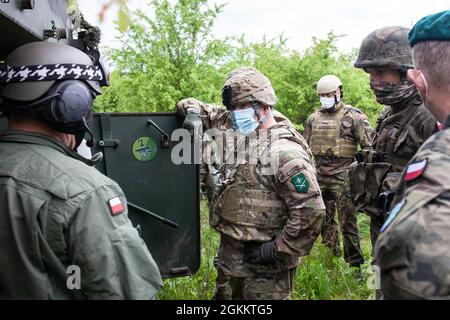 US Army LT. General Roger L. Cloutier Jr. , Kommandant des Alliierten Landkommandos, spricht mit einem Mitglied der AHS Krab System Crew der 5. Batterie, 2. Staffel, 5. Artillerieregiment der Polnischen Streitkräfte, 20. Mai 2021, im Artillerie- und Rüstungsausbildungszentrum, Während der Trainingsübung Dynamic Front 21 in Torun, Polen. Dynamic Front 21 ist eine vom 7. Army Training Command geführte, von der US Army Europe und Afrika geleitete Übung, die darauf abzielt, die Bereitschaft, die Letalität und die Interoperabilität zu erhöhen, indem sie die Fähigkeit der verbündeten und d Partnerländer ausübt, gemeinsame Brände in einem multinationalen Umfeld zu integrieren Stockfoto