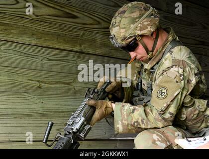 FORT DRUM, N.Y. – CPL der US-Armee. Dakoatah Miller, ein Infanterist des 2. Bataillons der New Yorker Nationalgarde, des 108. Infanterie-Regiments, zerlegt während der Beurteilung des „Expert Infantryman Badge“ der 10. Bergdivision in Fort Drum, N.Y., 20. Mai 2021 eine automatische M-249-Kader-Waffe. Stockfoto