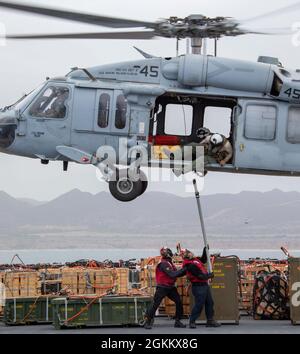 PAZIFISCHER OZEAN (20. Mai 2021) – US-Seeleute bereiten sich darauf vor, an Bord des amphibischen Sturmschiffs USS Makin Island (LHD 8) eine Munitionsmanschone der MH-60S anzuhaken, die dem Helicopter Sea Combat Squadron (HSC) 23 zugewiesen wurde. Die Makin Island Amphibious Ready Group und die 15. Marine Expeditionary Unit führen Routineoperationen im Einsatzgebiet der 3. US-Flotte durch. Stockfoto