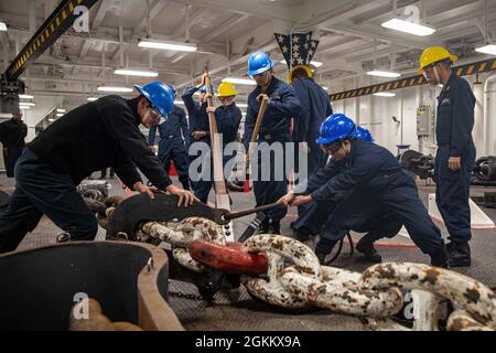 PAZIFISCHER OZEAN (20. Mai 2021) – Seeleute der US-Marine sichern sich an Bord des amphibischen Angriffsschiffs USS Makin Island (LHD 8) eine Ankerkette. Die Makin Island Amphibious Ready Group und die 15. Marine Expeditionary Unit führen Routineoperationen im Einsatzgebiet der 3. US-Flotte durch. Stockfoto