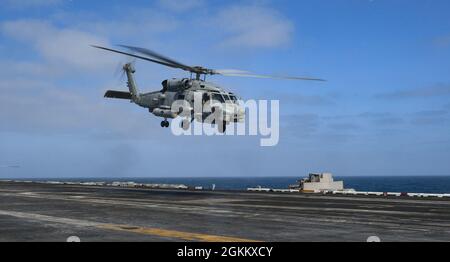 PAZIFISCHER OZEAN (20. Mai 2021) – ein MH-60R Sea Hawk, der dem „Wolf Pack“ des Helicopter Maritime Strike Squadron (HSM) 75 zugewiesen wurde, hebt am 71. Mai 2021 vom Flugdeck des Flugzeugträgers USS Theodore Roosevelt (CVN 20) ab. Die Theodore Roosevelt Strike Carrier Group befindet sich im geplanten Einsatz und führt Routineoperationen in der 3. US-Flotte durch. Stockfoto