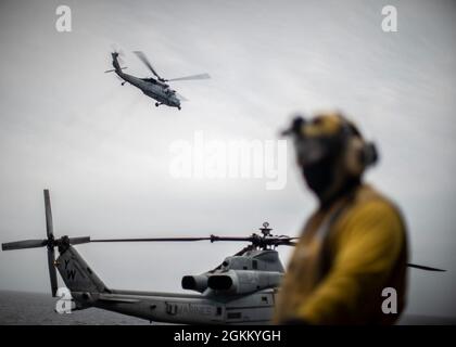 PACIFIC OCEAN (20. Mai 2021) Ein US Navy MH-60S Sea Hawk, der dem Hubschrauber Sea Combat Squadron (HSC) 21 zugewiesen wurde, hebt vom amphibischen Angriffsschiff USS Essex (LHD 2), 20. Mai ab. Marineinfanteristen und Segler der 11. MEU und der Essex Amphibious Ready Group (ARG) sind im Gange, um vor der Küste Südkaliforniens ein integriertes Training durchzuführen. Stockfoto