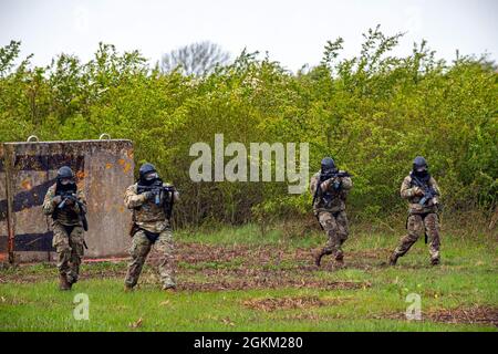 Flieger des 422d Security Forces Squadron, bringen ihre Position während einer Force-on-Force-Übung bei RAF Molesworth, England, 21. Mai 2021, unter Beschuss. Verteidiger des 422d und des 423. SFS kamen zusammen, um ihre Schieß-, Bewegen- und Kommunikationstaktiken zu schärfen, während sie auf mehrere Szenarien reagierten, die darauf ausgerichtet waren, ihre Fähigkeiten in tödlichen Gewaltsituationen zu schärfen. Stockfoto