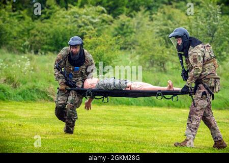 Flieger der 423. Sicherheitskräfte-Staffel tragen während einer Force-on-Force-Übung bei RAF Molesworth, England, 21. Mai 2021 ein simuliertes Opfer auf einer Bahre. Verteidiger des 422d und des 423. SFS kamen zusammen, um ihre Schieß-, Bewegen- und Kommunikationstaktiken zu schärfen, während sie auf mehrere Szenarien reagierten, die darauf ausgerichtet waren, ihre Fähigkeiten in tödlichen Gewaltsituationen zu schärfen. Stockfoto