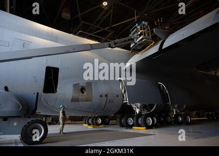 Senior Airman Tyler Bryce, links, entdeckt Staff Sgt. Brandin Josey, Center und Airman 1st Class Brandon Camp, 60. AMXS Aerospace Repair Specialists, während einer C-5M Super Galaxy Flügelplatteninspektion am 21. Mai 2021, Travis Air Force Base, Kalifornien. Die C-5 ist das größte Flugzeug im Bestand der Luftwaffe und ihre primäre Mission ist der Transport von Fracht und Personal für das Verteidigungsministerium. Stockfoto