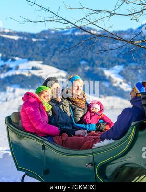 Genießen Sie Ihren Winterurlaub bei einer Pferdeschlittenfahrt im verschneiten Bregenzerwald Stockfoto