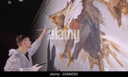 Der Designer zeichnet einen Adler an die Wand. Handwerker Dekorateure Stockfoto