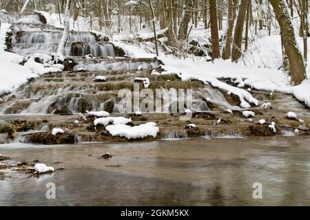 Schneebedeckter Wasserfall und Fluss im Winter Stockfoto
