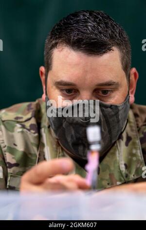 Technik. Sgt. Eric Barnes, ein Spezialist für die Reparatur von Kraftstoffsystemen, der der 158. Wartungsschwadron der Vermont Air National Guard zugewiesen wurde, bereitet Injektionen des Pfizer-BioNTech COVID-19-Impfstoffs im Collins Perley Complex in St. Albans, V., 22. Mai 2021 vor. Das Gesundheitsministerium von Vermont und die Nationalgarde von Vermont haben sich gemeinsam dafür eingesetzt, die Verabreichung des Impfstoffs an so viele Personen wie möglich zu beschleunigen, wobei Ende Mai mehr als 760,000 Dosen verabreicht wurden. Stockfoto