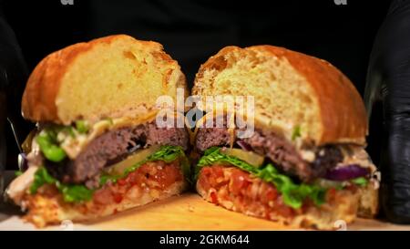 Cut Craft Burger kocht auf schwarzem Hintergrund. Soße n Stockfoto