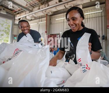 CAMP LEMONNIER, Dschibuti (23. Mai 2021) US Air Force Tech. Sgt. Deshawn Stallworth aus Fulton, Mo., Left, und Staff Sgt. Genise Murray aus Atlantic City, N.J., füllt während einer Betreuungspaketversammlungsveranstaltung in der Feuerwache von Camp Lemonnier am 23. Mai 2021 die Dankbarkeit-Taschen der Operation mit Snacks und Toilettenartikeln. Etwa 60 US-Truppen, die in Camp Lemonnier stationiert waren, sammelten über 3,500 Care-Pakete, die aus 5,700 kg Snacks und Hygieneartikeln bestehen, die durch Operation Danging gespendet wurden. Das amerikanische Rote Kreuz half bei der Lieferung und der Nachbetreuung im Lager. Freunde Afrikas unterstützt von Prov Stockfoto