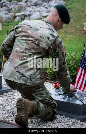 Ein Green Beret, der der 3rd Special Forces Group (Airborne) zugewiesen wurde, platziert eine Rose auf einem Soldatendenkmal während der SFG (A)-Gedenkwalk-Zeremonie 3 in Fort Bragg, NC, 25. Mai 2021. Familienmitglieder, Freunde und Soldatenkollegen aus Gold-Stars versammelten sich zum Gedenken an Soldaten, die im Einsatz gestorben sind, und ehrten ihr Gedächtnis, indem sie eine einzelne Rose auf ihren Gedenkstein stellten. Stockfoto