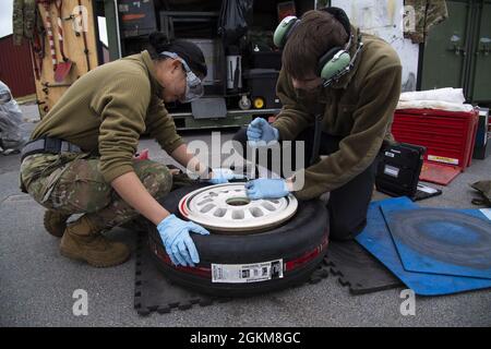 US Air Force Airmen vom 52. Wartungsgeschwader auf dem Luftwaffenstützpunkt Spangdahlem, Deutschland, bauen auf dem Luftwaffenstützpunkt Kallax, Schweden, 24. Mai 2021 einen Reifen für einen F-16. Die Rolle der Betreuer ist entscheidend, um sicherzustellen, dass die Flugzeuge des 52. Kampfflügels sofort einsatzbereit sind. Stockfoto