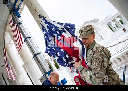 Der US-Armeekolonist Michael Binetti , Stabschef des Nationalfriedhofs von Arlington, hilft beim Aufhängen von US-Flaggen im Memorial Amphitheater auf dem Arlington National Cemetery, Arlington, Virginia, 25. Mai 2021. Stockfoto