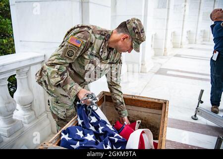 Der US-Armeekolonist Michael Binetti , Stabschef des Nationalfriedhofs von Arlington, hilft beim Aufhängen von US-Flaggen im Memorial Amphitheater auf dem Arlington National Cemetery, Arlington, Virginia, 25. Mai 2021. Stockfoto