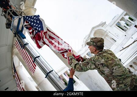 Der US-Armeekolonist Michael Binetti , Stabschef des Nationalfriedhofs von Arlington, hilft beim Aufhängen von US-Flaggen im Memorial Amphitheater auf dem Arlington National Cemetery, Arlington, Virginia, 25. Mai 2021. Stockfoto