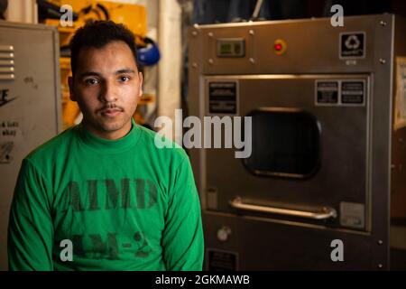 210525-N-TE455-1019 ARABIAN SEA (25. Mai 2021) - Aviation Structural Mechanic Airman Lehrling Scott Kochell posiert für ein Foto an Bord des Flugzeugträgers USS Dwight D. Eisenhower (CVN 69) im Arabischen Meer, 25. Mai. Die Eisenhower Carrier Strike Group wird im Einsatzgebiet der 5. US-Flotte eingesetzt, um Marineinoperationen zu unterstützen und Luftstrom zu liefern, um US- und Koalitionstruppen zu schützen, während sie Abziehoperationen aus Afghanistan durchführen. Stockfoto