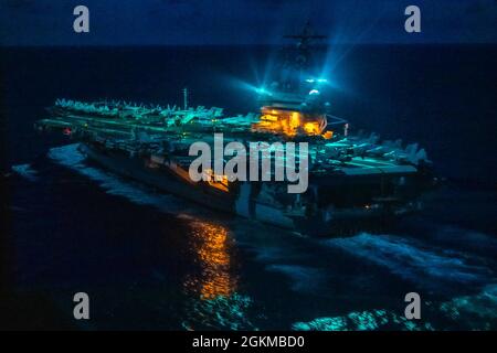 210525-N-JW440-4289 PHILIPPINISCHES MEER (25. Mai 2021) der Flugzeugträger USS Ronald Reagan (CVN 76) der Nimitz-Klasse durchfliegt nachts das philippinische Meer. Reagan ist das Flaggschiff von Commander, Task Force 70/Carrier Strike Group 5, die laufende Operationen zur Unterstützung eines freien und offenen Indo-Pazifik-Raums durchführt. Stockfoto