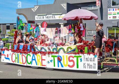 Kleine Kinder und ihre Betreuer reiten in einem Festwagen während einer Weihnachtsparade in Rotorua, Neuseeland Stockfoto