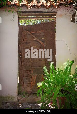 Eine alte, patinierte Tür in Castellar de la Correa in der Provinz Caáz, Andalusien, Spanien, die sich in einer maurisch-christlichen Festung befindet. Stockfoto