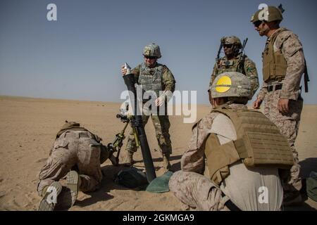 Ein Oberst der Luftwaffe mit dem 386. Air Expeditionary Wing und US-Marineinfanteristen mit dem 3. Bataillon 1st Marines, der Special Purpose Marine Air-Ground Task Force – Crisis Response – Central Command (SPMAKTF CR-CC) zugewiesen wurde, markieren Ziele für Flugzeuge mit Mörsern während eines Live-Feuers in Kuwait, 26. Mai 2021. Die SPMAGTF-CR-CC ist eine Krisenreaktionskraft, die bereit ist, eine Vielzahl von Fähigkeiten in der gesamten Region einzusetzen. Stockfoto