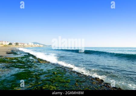 Mittelmeer-Küste des Strandes, steinerne Meer und Wellen plätschernden, blauen sauberen Himmel Stockfoto