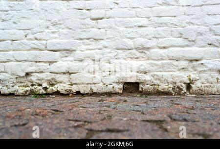 Leere gemauerte Mauer und alter Straßenbelag Stockfoto