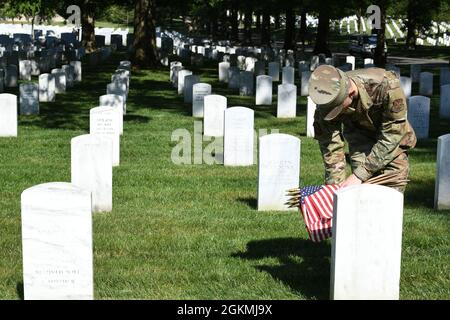 US Air Force Airman 1st Class Michael Hester, Ehrengarde der US Air Force, platziert während des „Flags-in“, 27. Mai, eine amerikanische Flagge auf dem Arlington National Cemetery, Arlington, VA. 2021. Jedes Jahr vor dem Memorial Day werden auf jedem Grabstein auf dem Friedhof mehr als 280,000 Flaggen zu Ehren der gefallenen Helden der Nationen aufgestellt. Stockfoto