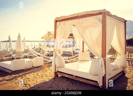 Romantische Entspannung auf Luxus-Sonnenliege am Strand in Das Mittelmeer Stockfoto
