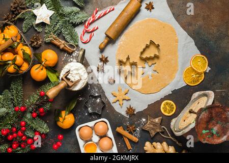 Essen im Urlaub. Zutaten für die Herstellung von Weihnachts-Ingwerkeksen, kleinen Bäumen und Schneeflocken. Mandarinen, Tannenbaum, Süßigkeiten. Stockfoto