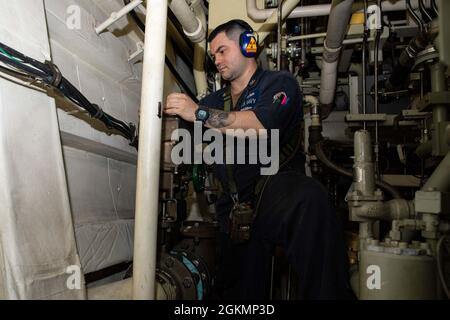 210528-N-RL695-1078 CARIBBEAN SEA - (28. Mai 2021) -- Gasturbinensystemtechniker (Elektrik), 1. Klasse Dominic Dieppa, der dem Freedom-Variant Littoral Combat Ship USS Sioux City (LCS 11) zugewiesen wurde, führt Wartungsarbeiten an einem motorbetriebenen Ventil (MOV) im Hauptmaschinenraum durch, 28. Mai 2021. Sioux City wird in den Einsatzbereich der 4. US-Flotte entsandt, um die Mission der Joint Interagency Task Force South zu unterstützen, die auch Einsätze zur Bekämpfung des illegalen Drogenhandels in der Karibik und im Ostpazifik umfasst. Stockfoto