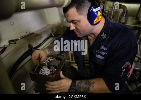 210528-N-RL695-1091 CARIBBEAN SEA - (28. Mai 2021) -- Gasturbinensystemtechniker (Elektrik), 1. Klasse Dominic Dieppa, der dem Freedom-Variant Littoral Combat Ship USS Sioux City (LCS 11) zugewiesen wurde, führt Wartungsarbeiten an einem motorbetriebenen Ventil (MOV) im Hauptmaschinenraum durch, 28. Mai 2021. Sioux City wird in den Einsatzbereich der 4. US-Flotte entsandt, um die Mission der Joint Interagency Task Force South zu unterstützen, die auch Einsätze zur Bekämpfung des illegalen Drogenhandels in der Karibik und im Ostpazifik umfasst. Stockfoto