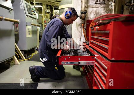 210528-N-RL695-1094 KARIBISCHES MEER - (28. Mai 2021) -- Gasturbinensystemtechniker (elektrisch) Dominic Dieppa, der dem Freedom-Variant Littoral Combat Ship USS Sioux City (LCS 11) zugeordnet ist, bereitet sich auf die Wartung im Hauptmaschinenraum vor, 28. Mai 2021. Sioux City wird in den Einsatzbereich der 4. US-Flotte entsandt, um die Mission der Joint Interagency Task Force South zu unterstützen, die auch Einsätze zur Bekämpfung des illegalen Drogenhandels in der Karibik und im Ostpazifik umfasst. Stockfoto