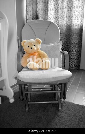 Teddybär im Schaukelstuhl im Kinderzimmer-Interieur Stockfoto